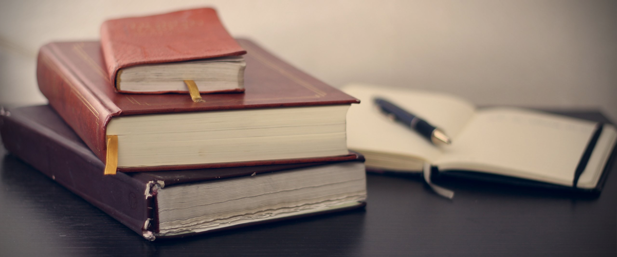 A stack of theology books and a Bible.